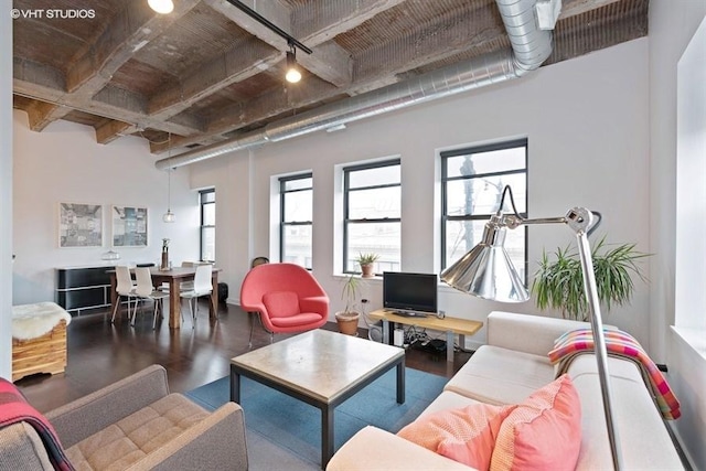 living room with a towering ceiling, wood-type flooring, and beam ceiling