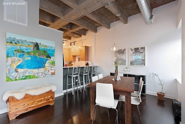 dining space with dark hardwood / wood-style flooring and a high ceiling