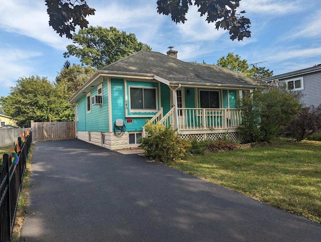 view of front of home with cooling unit, a porch, and a front lawn