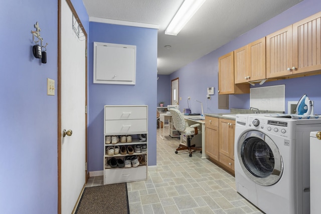 laundry area with a textured ceiling, a sink, baseboards, cabinet space, and washer / dryer