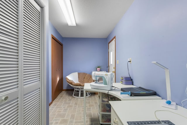 interior space with a textured ceiling and baseboards