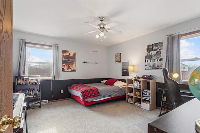 carpeted bedroom with multiple windows and a ceiling fan