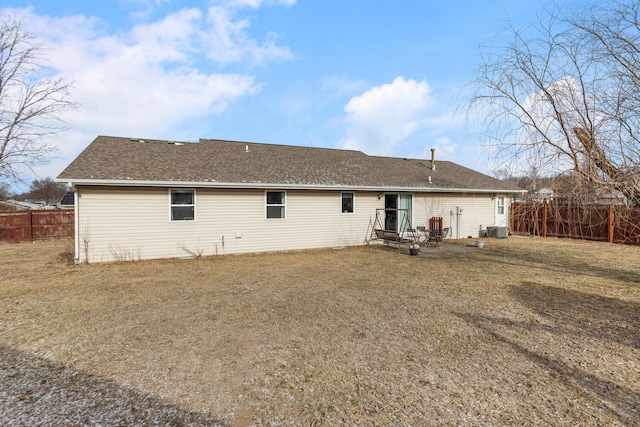 back of property featuring a shingled roof, a lawn, cooling unit, and fence