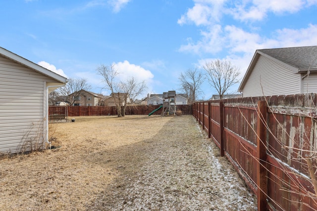 view of yard with a residential view, a playground, and a fenced backyard