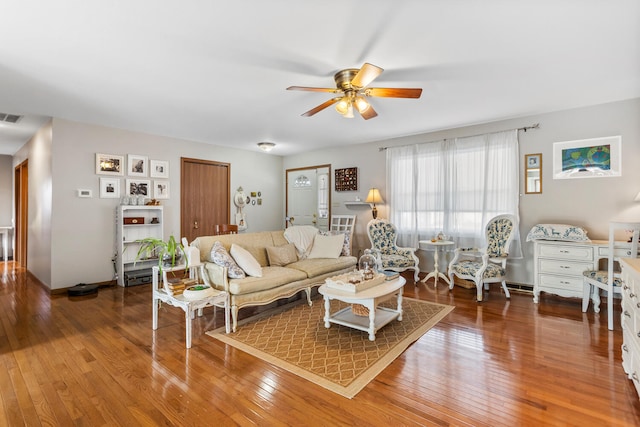 living room with a ceiling fan, visible vents, and wood finished floors