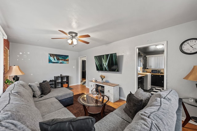 living room featuring ceiling fan and light hardwood / wood-style flooring