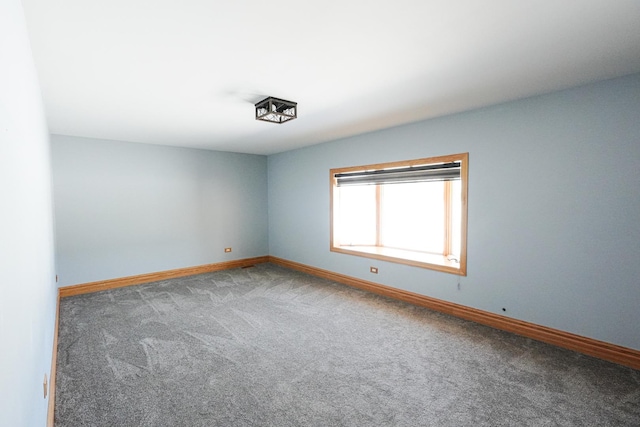 carpeted empty room with baseboards