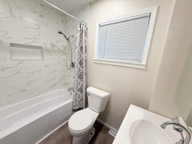 full bathroom featuring sink, hardwood / wood-style floors, shower / tub combo, and toilet