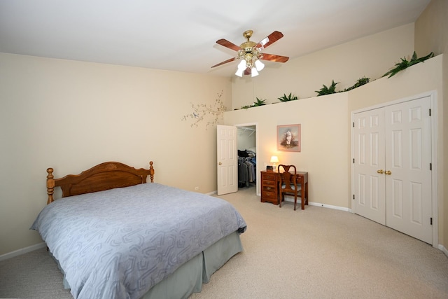 bedroom with baseboards, light colored carpet, ceiling fan, a spacious closet, and a closet