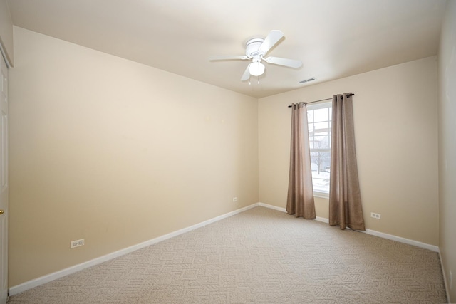 unfurnished room featuring ceiling fan, visible vents, light colored carpet, and baseboards