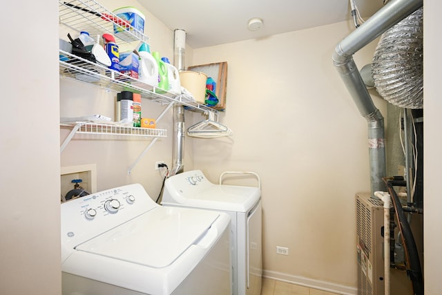 laundry area with laundry area, washing machine and dryer, and baseboards