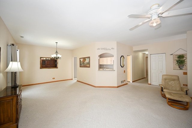 unfurnished room featuring light colored carpet, visible vents, baseboards, and ceiling fan with notable chandelier