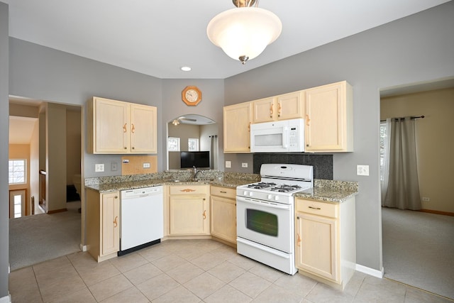 kitchen featuring light carpet, white appliances, and light brown cabinetry