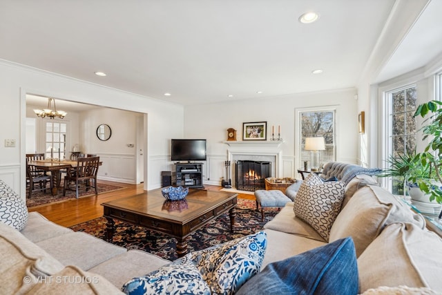 living room with an inviting chandelier, hardwood / wood-style floors, and ornamental molding