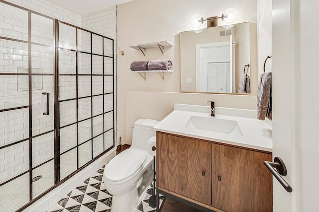 bathroom with vanity, a shower with shower door, and toilet