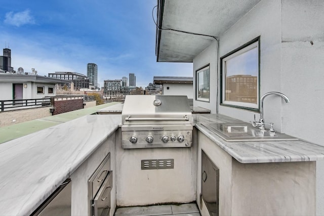 view of patio featuring grilling area, exterior kitchen, sink, and a balcony