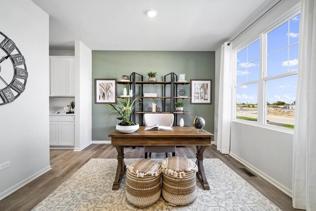 kitchen featuring white cabinets, recessed lighting, light countertops, freestanding refrigerator, and light wood-style flooring