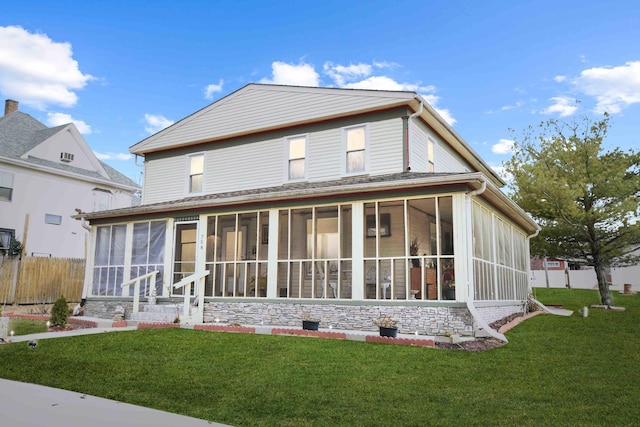 back of house featuring a yard and a sunroom