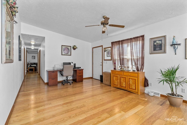 office featuring ceiling fan, light hardwood / wood-style flooring, and a textured ceiling