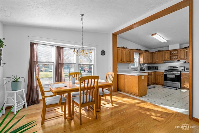 kitchen with gas range, plenty of natural light, sink, and hanging light fixtures