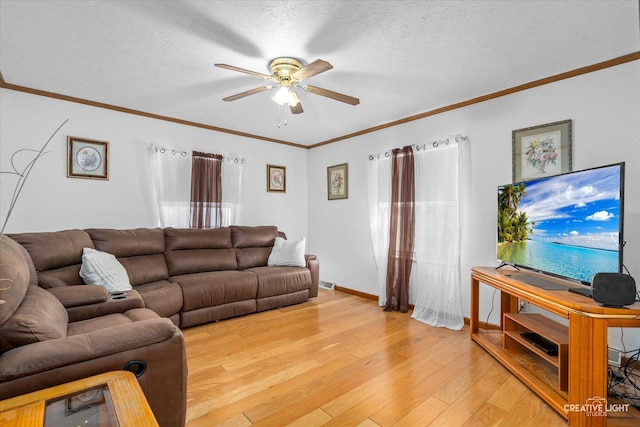 living room with crown molding, ceiling fan, light hardwood / wood-style flooring, and a textured ceiling