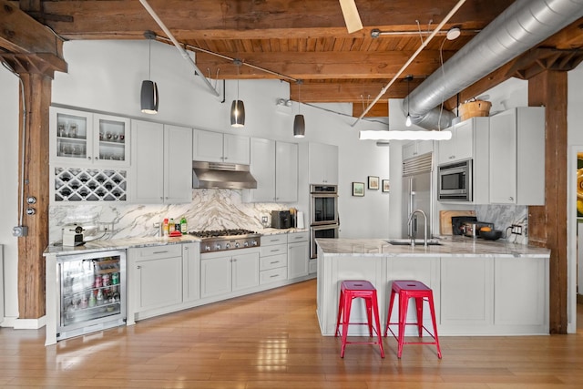 kitchen featuring white cabinetry, built in appliances, and wine cooler