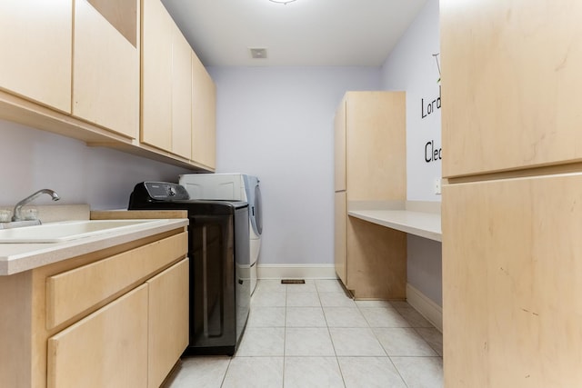 laundry area with sink, light tile patterned floors, cabinets, and washing machine and clothes dryer