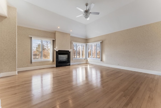 unfurnished living room with a wealth of natural light, ceiling fan, and light hardwood / wood-style flooring