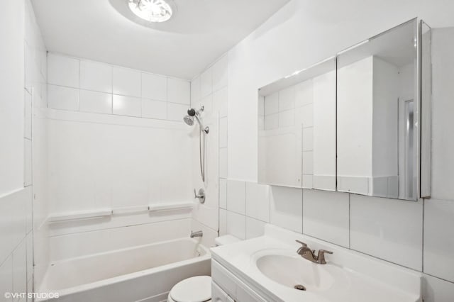 full bathroom featuring tiled shower / bath combo, vanity, tile walls, and toilet