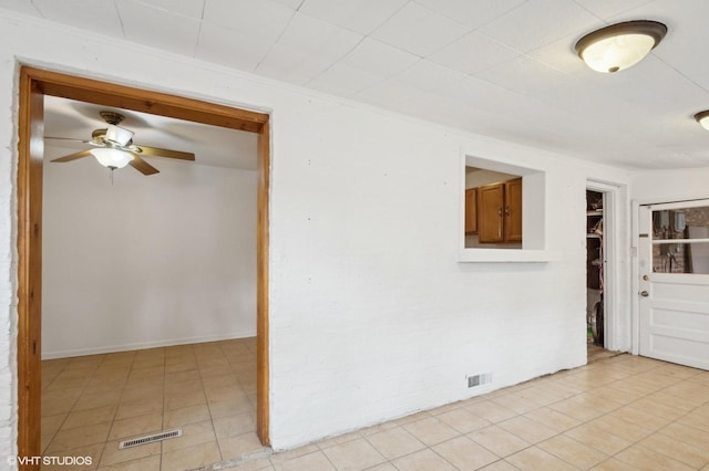 tiled spare room with ceiling fan