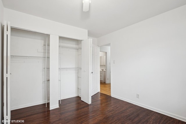 unfurnished bedroom featuring dark hardwood / wood-style floors, ceiling fan, and a closet