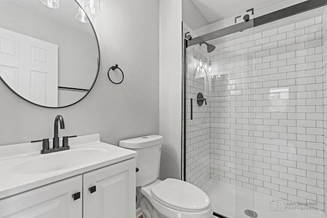 bathroom featuring vanity, toilet, and walk in shower