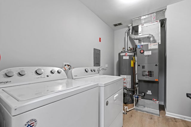 washroom with gas water heater, light wood-type flooring, electric panel, and independent washer and dryer