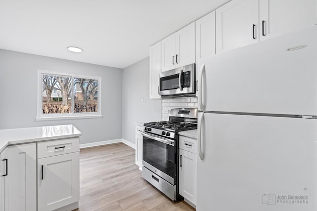 kitchen featuring white cabinetry, decorative backsplash, and appliances with stainless steel finishes