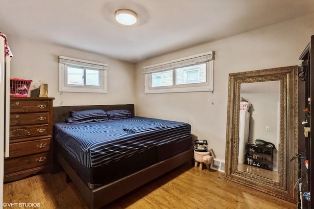 bedroom with multiple windows and light hardwood / wood-style flooring