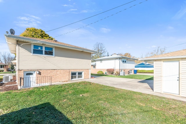 rear view of house featuring a yard, central AC unit, and a patio area