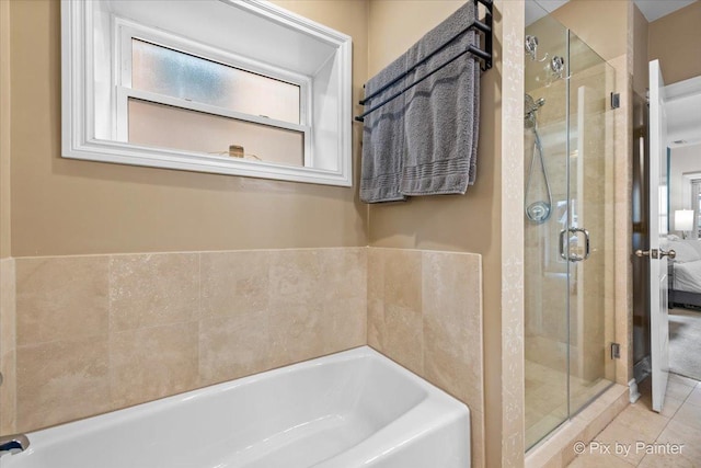 bathroom featuring a shower stall, a bath, and tile patterned floors