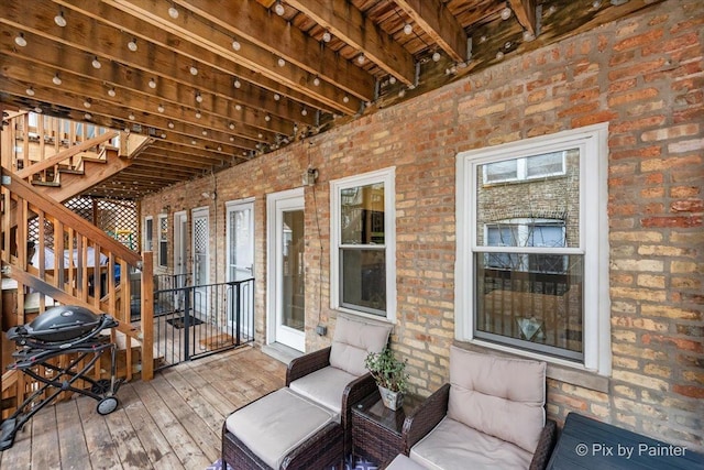 wooden deck with area for grilling and stairs