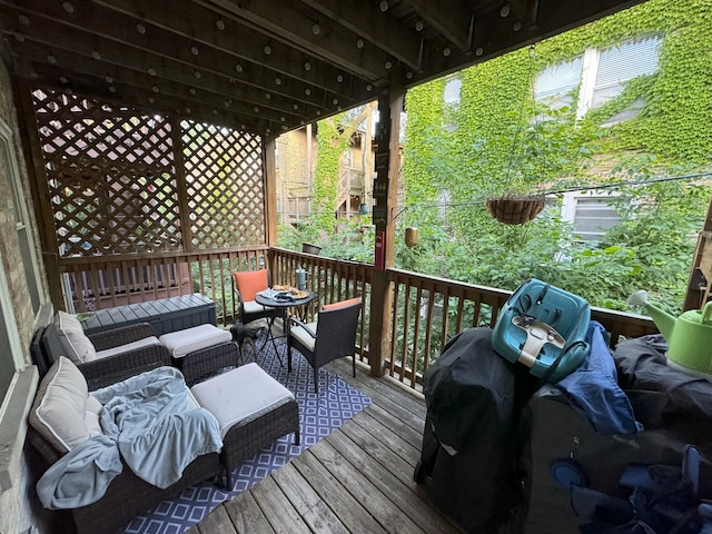 wooden terrace with grilling area and an outdoor living space