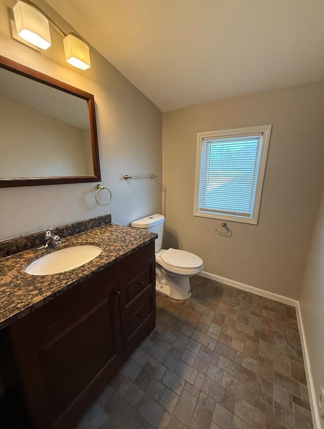 bathroom with vanity, vaulted ceiling, and toilet