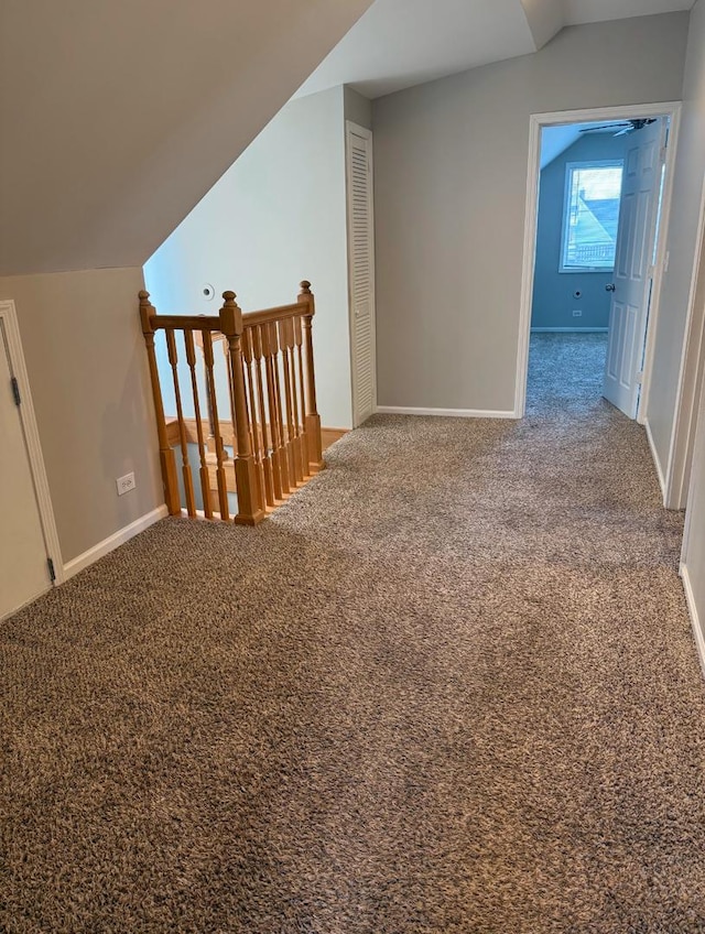 additional living space with vaulted ceiling and carpet flooring