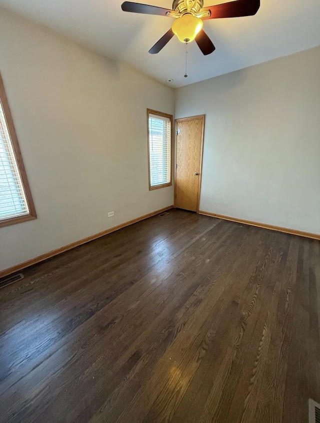 spare room with dark hardwood / wood-style floors and ceiling fan