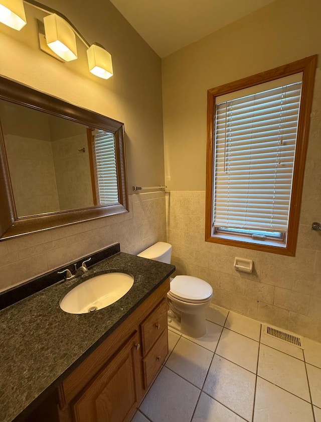 bathroom featuring vanity, tile patterned floors, toilet, and tile walls