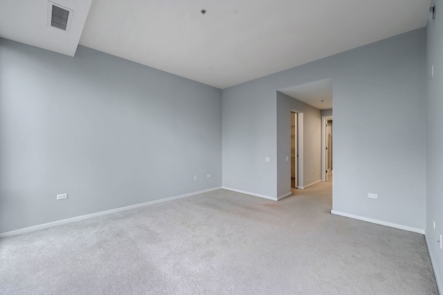 spare room with visible vents, light carpet, and baseboards