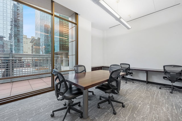 office space with carpet floors, a view of city, and baseboards