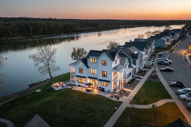 aerial view at dusk featuring a water view