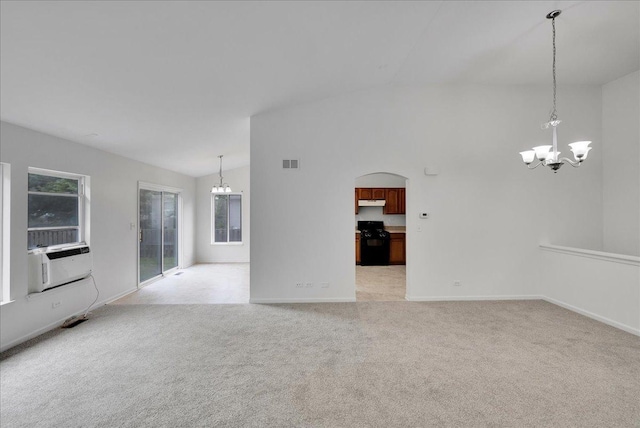 carpeted empty room with cooling unit, high vaulted ceiling, and a notable chandelier