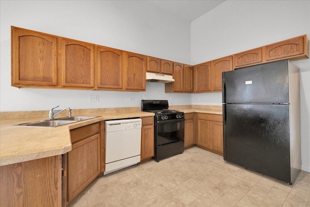 kitchen with a towering ceiling, sink, and black appliances