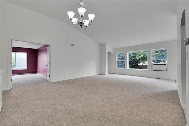 unfurnished living room featuring light colored carpet, a chandelier, and high vaulted ceiling