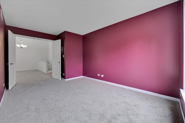 carpeted empty room with a chandelier